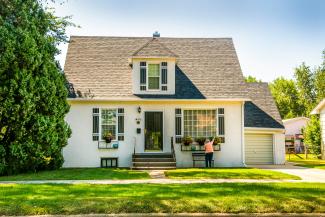 white house with green lawn and trees by Ian MacDonald courtesy of Unsplash.