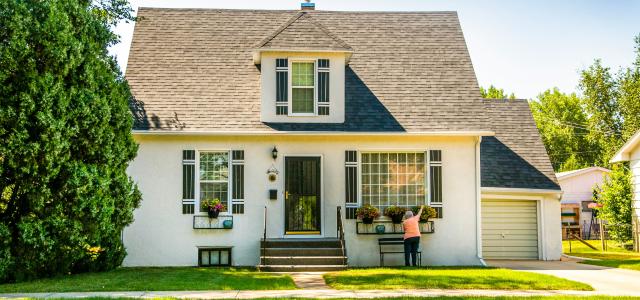 white house with green lawn and trees by Ian MacDonald courtesy of Unsplash.